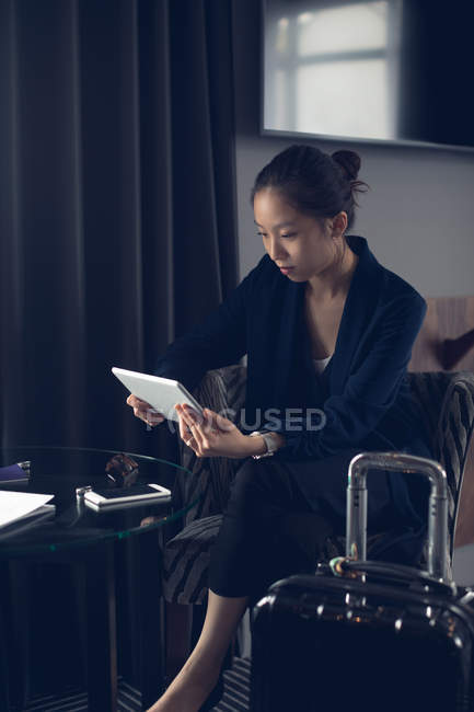 Женщина с помощью цифрового планшета в отеле — стоковое фото