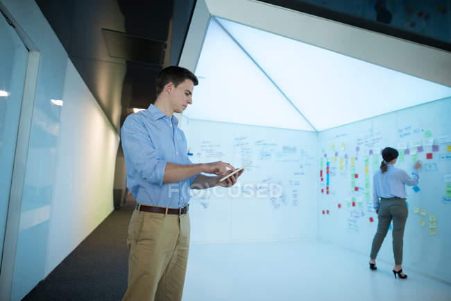 Ejecutivo masculino usando tableta digital en oficina futurista - foto de stock