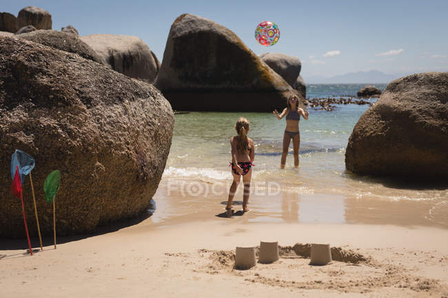 Irmãos brincando com bola no mar na praia — Fotografia de Stock