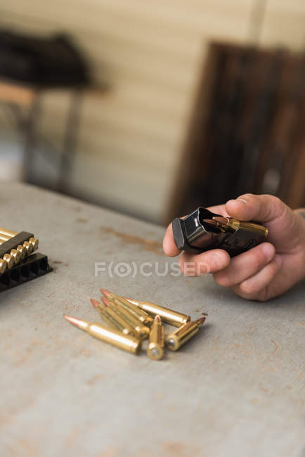 Close-up of man holding bullets in hand — Stock Photo