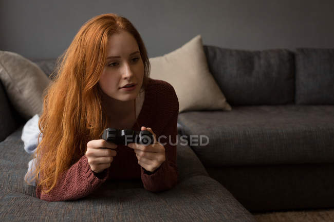 Young woman playing video games at home — Stock Photo