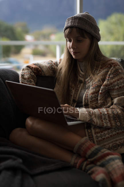 Donna che utilizza il computer portatile in soggiorno a casa
. — Foto stock