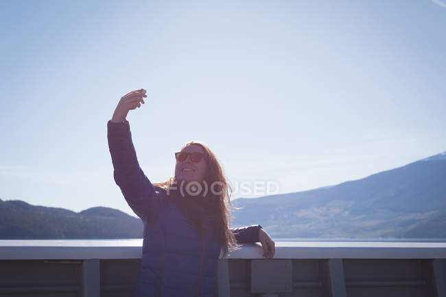 Красива жінка бере селфі з мобільним телефоном в сонячний день — стокове фото