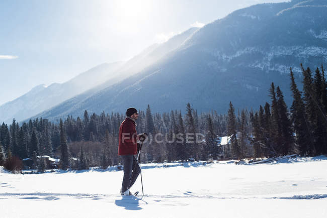 Hombre caminando con bastones de esquí en el paisaje nevado durante el invierno . - foto de stock
