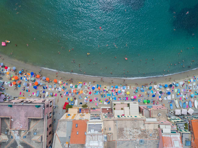 Overhead view of beach umbrellas and building along the sea coast — Stock Photo
