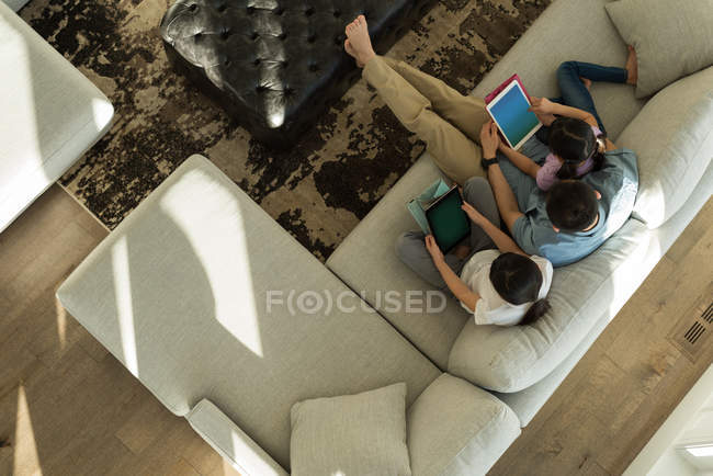Visão aérea de meninas usando tablet digital com seu pai na sala de estar em casa — Fotografia de Stock