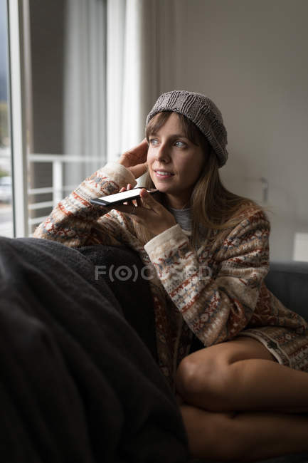 Femme parlant sur téléphone portable dans le salon à la maison . — Photo de stock