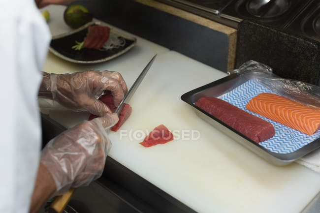 Mid section of chef preparing sushi in kitchen — Stock Photo