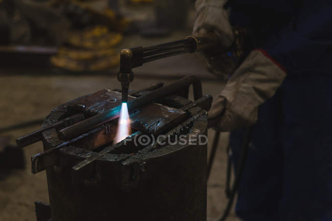 Mid section of welder repairing vessel part in workshop — Stock Photo