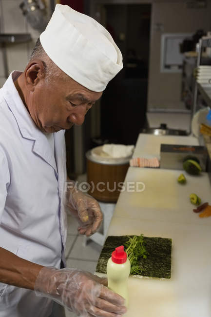 Chef sênior preparando sushi na cozinha do hotel — Fotografia de Stock