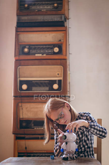 Menina consertando o brinquedo robótico em casa — Fotografia de Stock