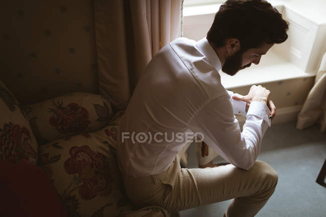 Thoughtful groom sitting on the sofa at home — Stock Photo