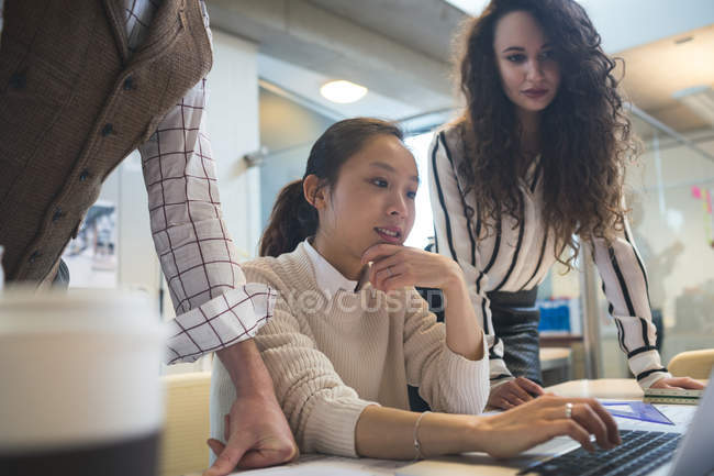 Executives discussing over laptop in modern office — Stock Photo