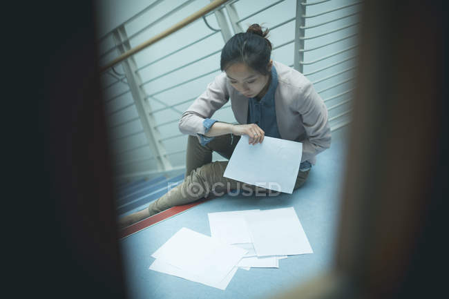 Mulher executiva lendo um documento no cargo — Fotografia de Stock