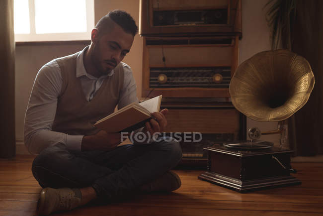 Mann liest Buch zu Hause auf dem Fußboden — Stockfoto