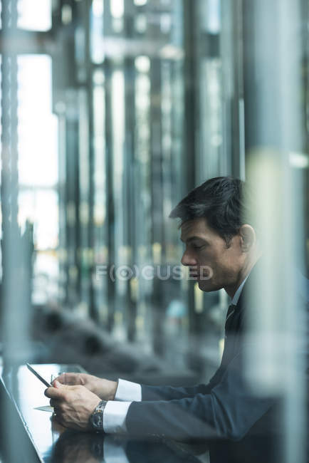 Empresário usando telefone celular no balcão do hotel — Fotografia de Stock