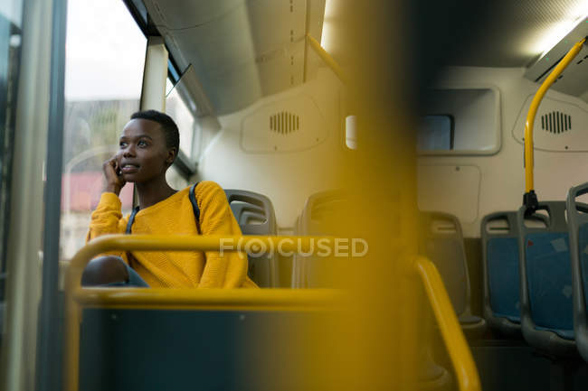 Mujer joven mirando por la ventana mientras viaja en autobús - foto de stock