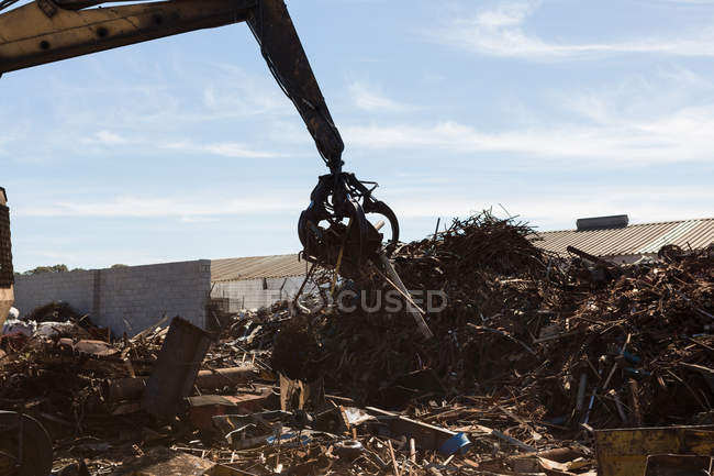 Crane lifting scrap metal in the junkyard — Stock Photo