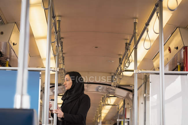 Thoughtful woman in hijab travelling in train — Stock Photo