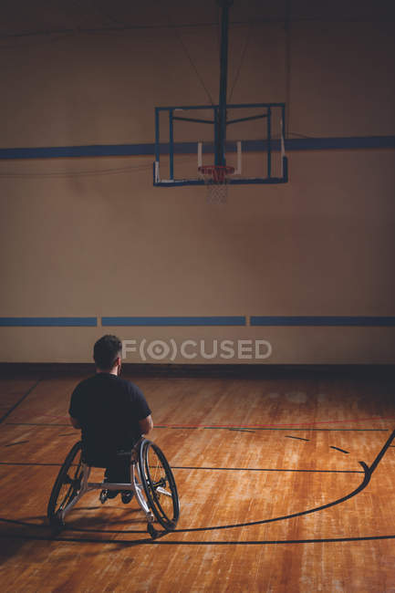 Disabled man looking at basketball hoop in the court — Stock Photo