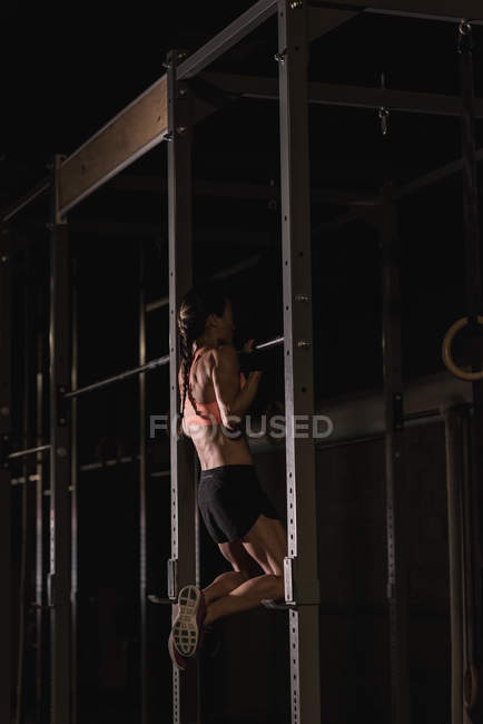 Подтянутая женщина делает подтягивание в студии — стоковое фото
