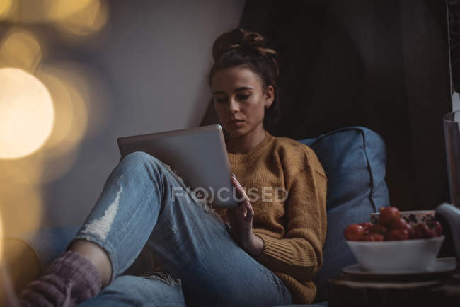 Mujer concentrada usando tableta digital en casa - foto de stock