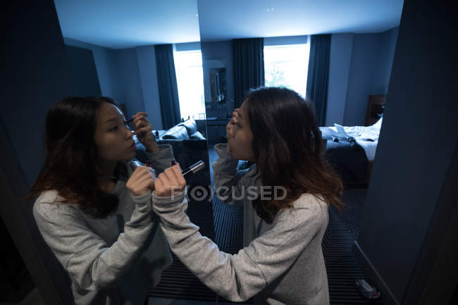 Donna che applica il mascara davanti allo specchio — Foto stock