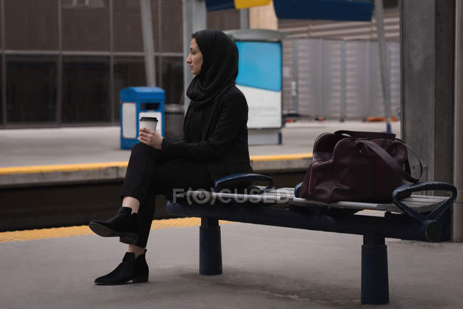 Задумчивая женщина в хиджабе ждет на вокзале — стоковое фото