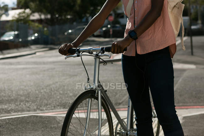 Frau läuft mit Fahrrad in Stadtstraße — Stockfoto