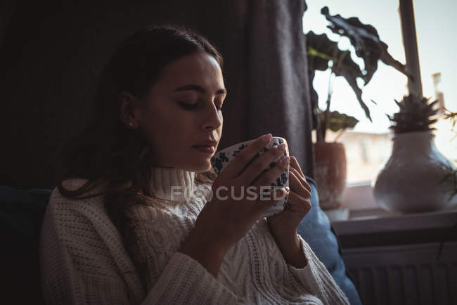 Mulher bonita cheirando o aroma do chá em casa — Fotografia de Stock