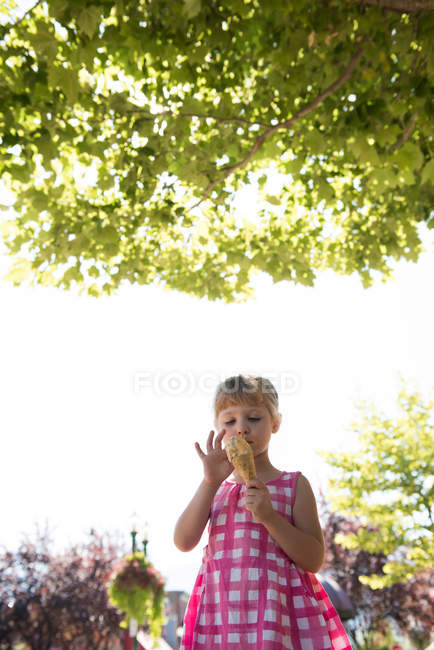 Linda chica teniendo helado en un día soleado - foto de stock
