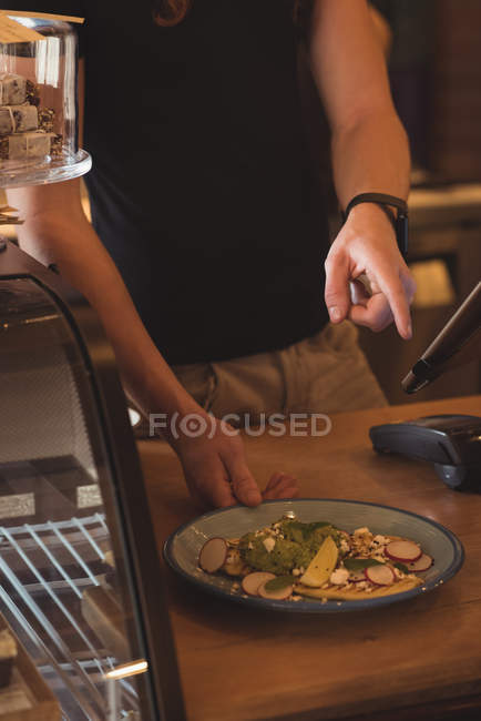 Mid section of waiter taking order on digital tablet in cafe — Stock Photo