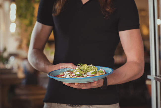 Mittelteil des Kellners hält Salat im Café — Stockfoto