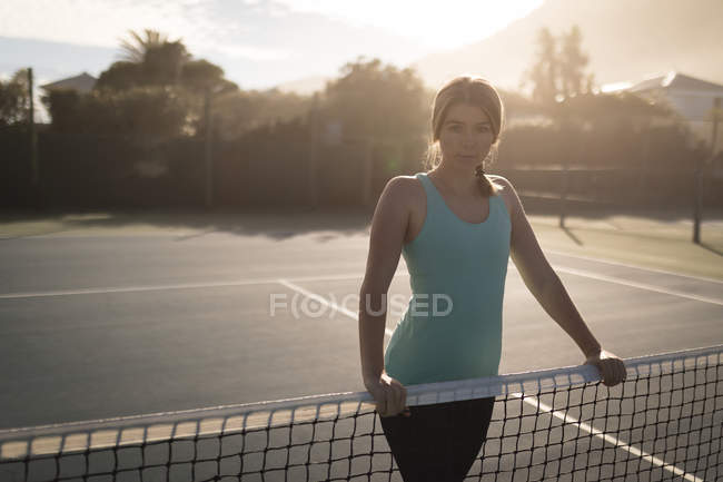 Портрет жінки, що стоїть у тенісному корті — стокове фото