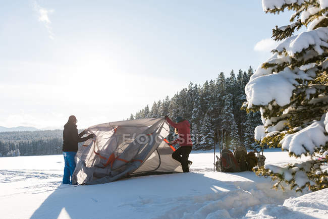 Coppia tenda pitching nel paesaggio innevato durante l'inverno
. — Foto stock