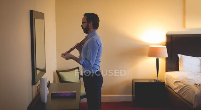 Homme d'affaires s'habillant devant le miroir de la chambre d'hôtel — Photo de stock
