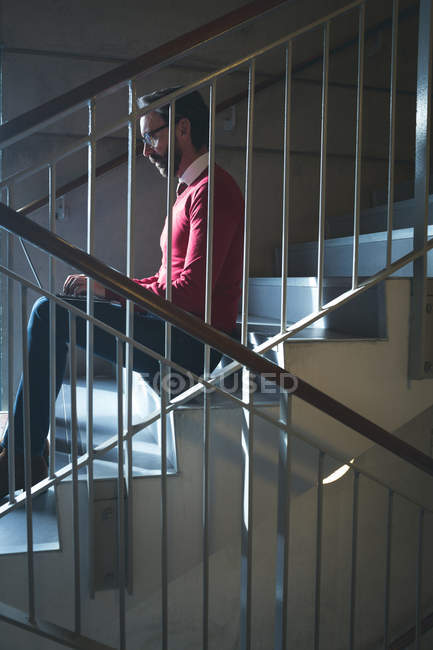 Führungskräfte nutzen Laptop auf Treppen im modernen Büro — Stockfoto
