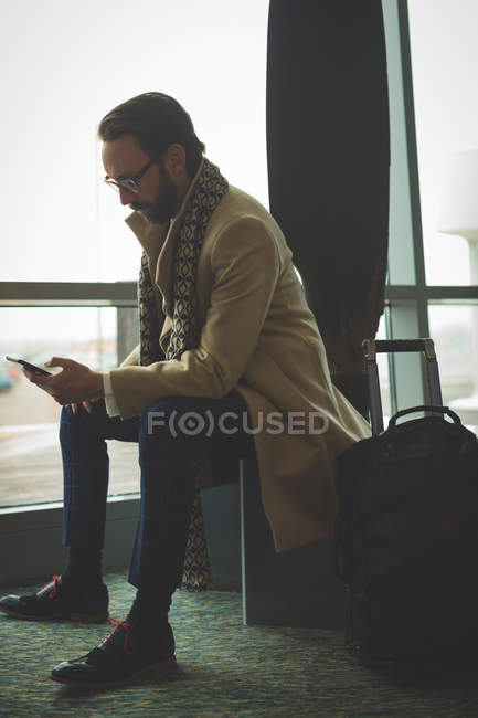 Businessman using mobile phone in hotel lobby — Stock Photo