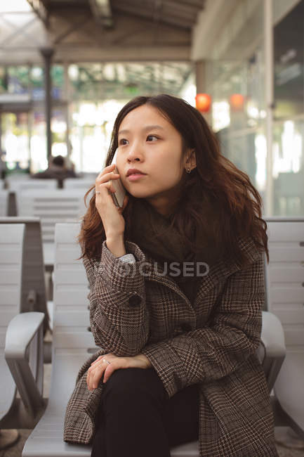 Красивая женщина разговаривает по мобильному телефону на железнодорожной платформе — стоковое фото