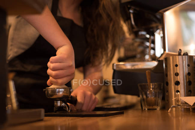 Mid section of barista preparing coffee in cafe — Stock Photo