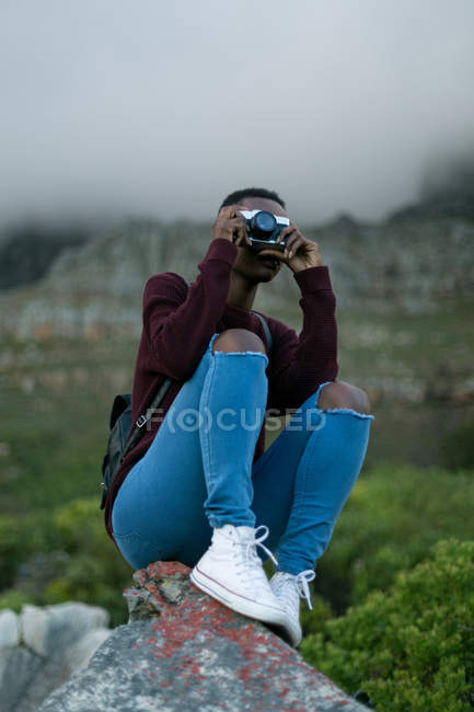 Женщина фотографируется с винтажной камерой в сельской местности — стоковое фото