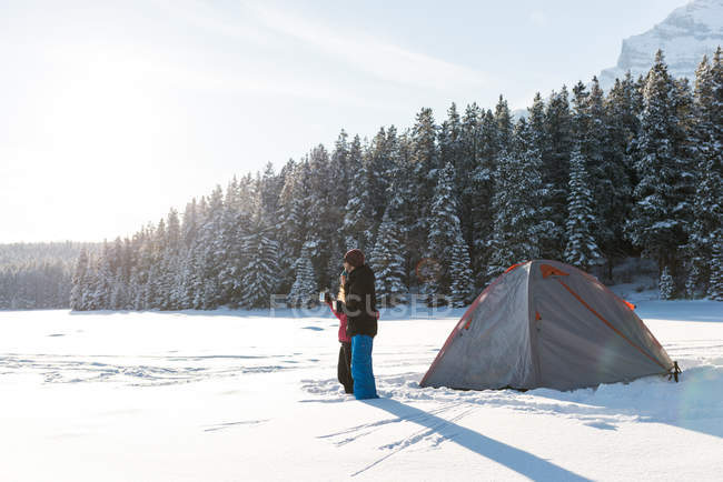 Paar teilt Heißgetränk im Winter in verschneiter Landschaft. — Stockfoto