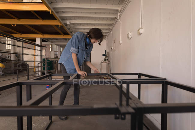 Junge Kunsthandwerkerin arbeitet in Werkstatt. — Stockfoto