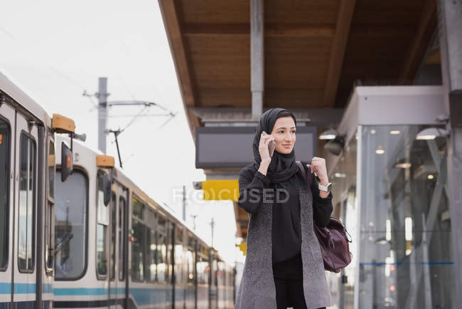 Жінка в хіджабі розмовляє по мобільному телефону на вокзалі — стокове фото