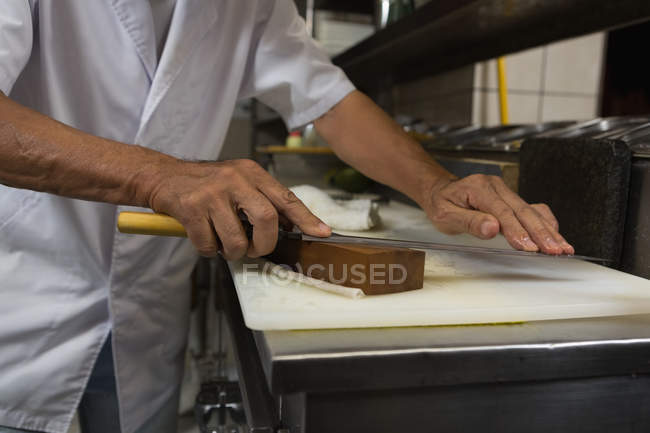 Chefe sênior segurando faca na cozinha do hotel — Fotografia de Stock