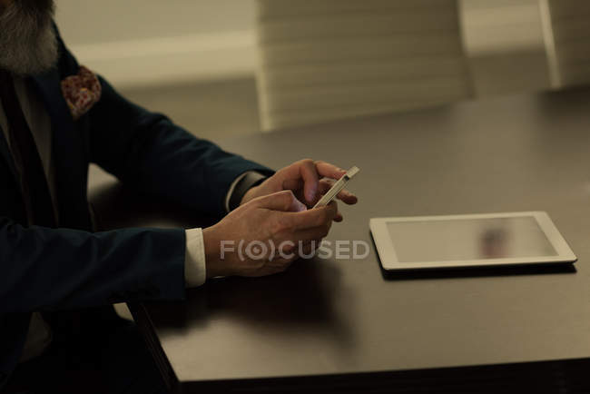 Business executive using mobile phone in office — Stock Photo
