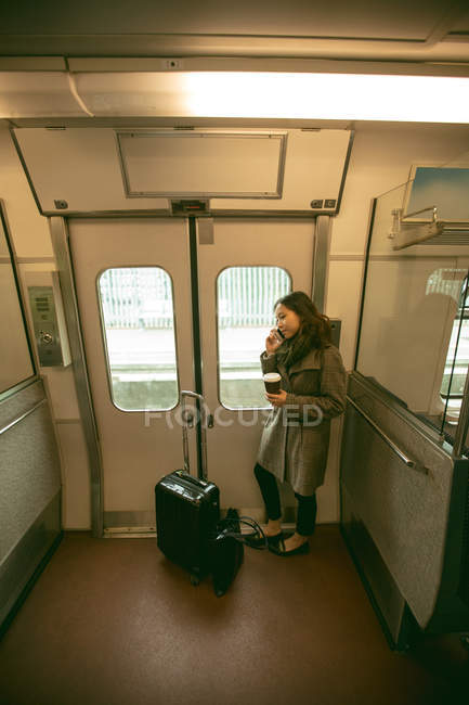 Женщина разговаривает по мобильному телефону во время путешествия в поезде — стоковое фото