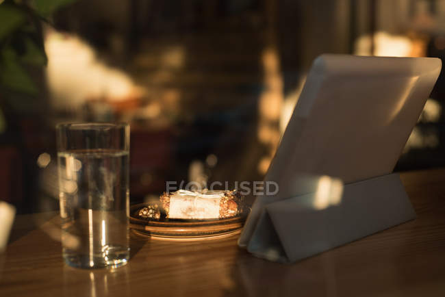 Digital tablet and breakfast on table in cafe — Stock Photo