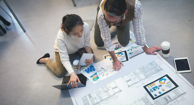 Executives discussing over blueprint in modern office — Stock Photo