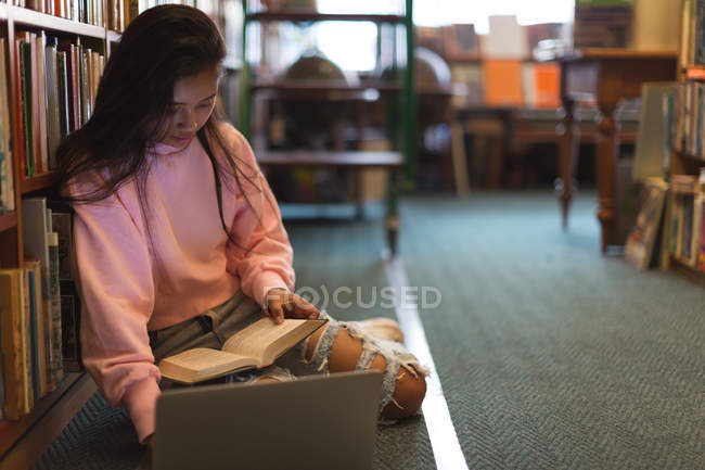 Asiático adolescente menina usando laptop na biblioteca — Fotografia de Stock